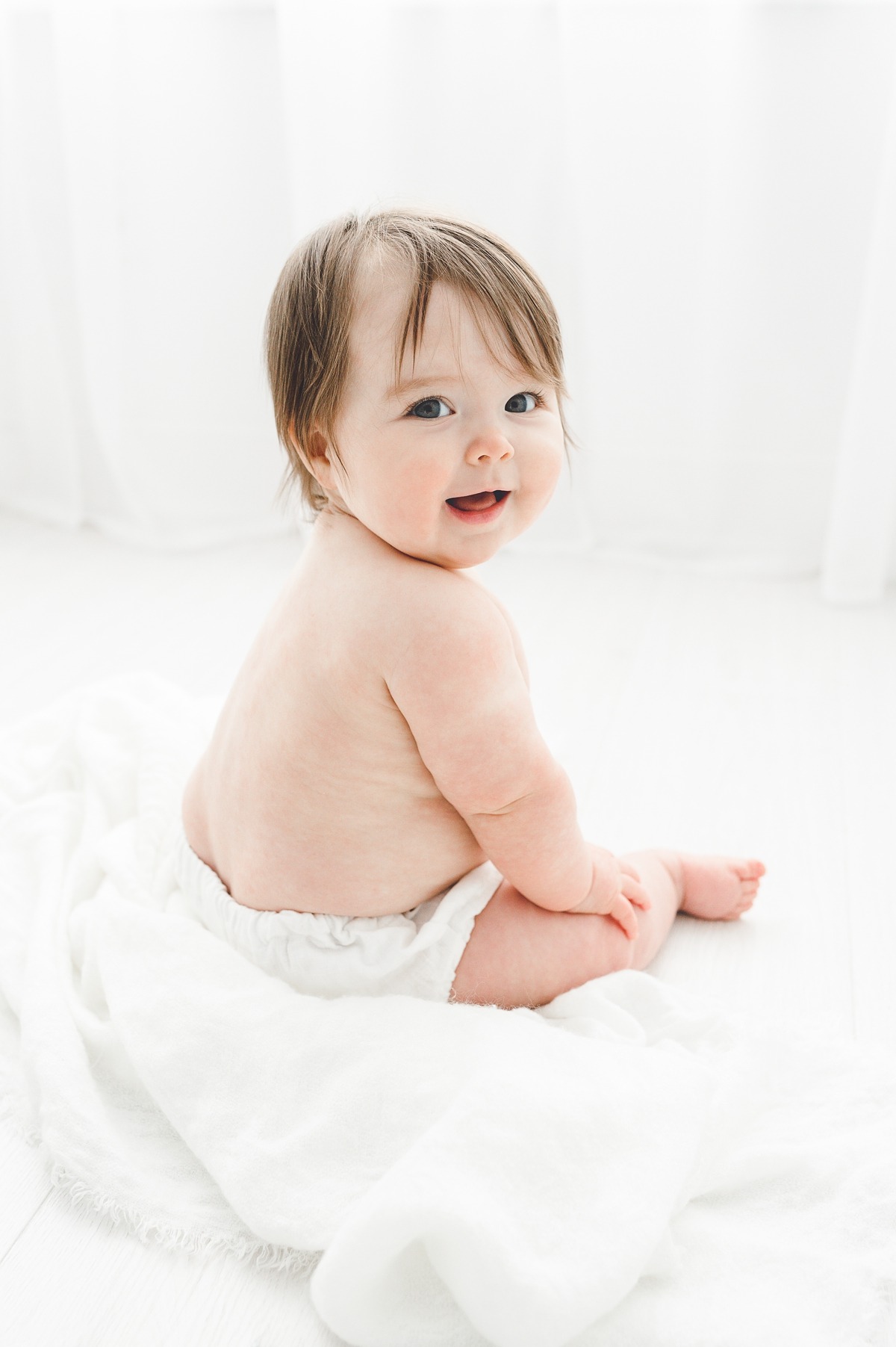 Timeless image of baby sitting and smiling